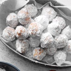 powdered sugar covered donuts in a metal bowl