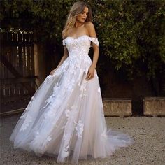 a woman in a white wedding dress standing outside