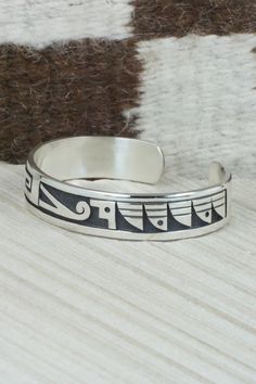 This sterling silver bracelet was made by Hopi silversmith Timothy Mowa. The inside is signed and stamped sterling.Size: 5 5/8" (will fit up to a 6 3/8" wrist)Gap: 3/4"Width: 1/2"Free shipping on all orders! We ship with USPS and always include tracking. All orders ship within a day of payment.Returns are accepted up to 30 days after you receive your order. Just send us a message. Our shop offers cash back or store credit. The item must be returned in new condition. Sterling Silver Etched Bracelets For Anniversary, Adjustable Sterling Silver Bangle For Ceremonial Occasion, Unique Engraved Anniversary Bracelets, Sterling Silver Collectible Bangle, Sterling Silver 925 Stamped Bracelets For Anniversary, Sterling Silver Spiritual Bracelet For Anniversary, Spiritual Sterling Silver Bracelet For Anniversary, Unique Etched Sterling Silver Adjustable Bracelet, Unique Adjustable Etched Sterling Silver Bracelet