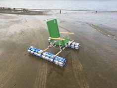 a lawn chair sitting on top of a sandy beach next to the ocean with empty beer cans