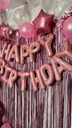 balloons and streamers in the shape of letters that spell happy birthday on a pink background