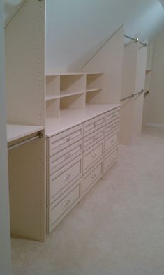 an empty room with many drawers and shelves on the wall next to a closet door