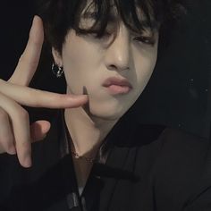 a man with black hair making the peace sign