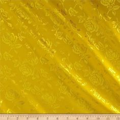 a ruler is next to a yellow fabric with flowers and leaves on it's side