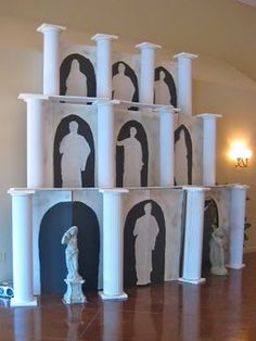 several white pillars with black and white images on them in the middle of a room