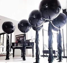 black balloons with tassels in front of a piano