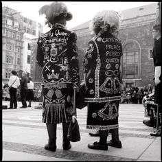 two people dressed in costumes walking down the street