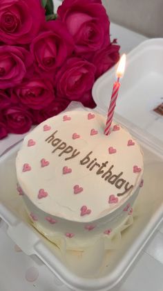 a birthday cake sitting on top of a white plate with pink roses in the background