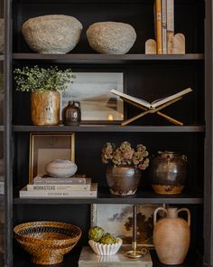 a bookshelf filled with vases and other items