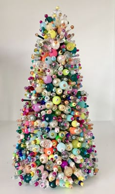 a colorful christmas tree with lots of ornaments on it's top and bottom half