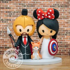 a wedding cake topper with mickey and minnie mouse figurines next to each other