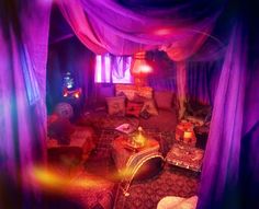 a room with purple curtains and couches in it