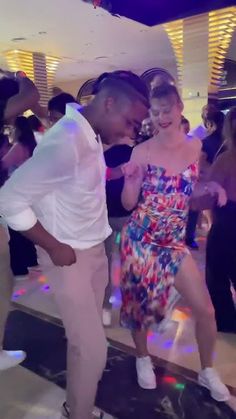 a man and woman dancing on the dance floor in front of other people at a party