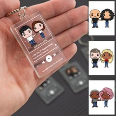 a person holding a keychain with different avatars on it