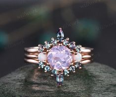 a pink ring with blue and white stones on it