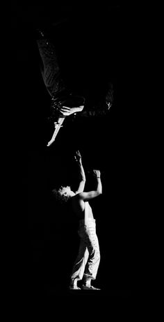 black and white photograph of two people jumping in the air with one person upside down