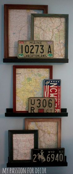 three framed license plates are mounted on the wall above a map and other decorative items