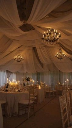 a banquet hall with chandeliers, tables and chairs