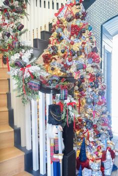 a decorated christmas tree sitting on top of a stair case