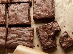 chocolate brownies cut into squares on top of parchment paper next to a rolling pin