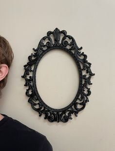 a man standing in front of a wall with a mirror on it's face