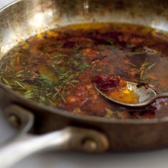 a spoon full of soup sitting on top of a pan