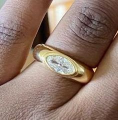 a close up of a person's hand with a diamond ring on their finger