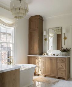 a bath room with a tub a sink and a large mirror on the wall in front of a window