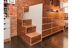 a room that has some drawers on the side and stairs in front of it,