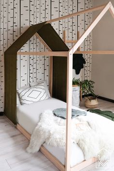 a bed with a wooden frame and white fur rugs on the floor next to it