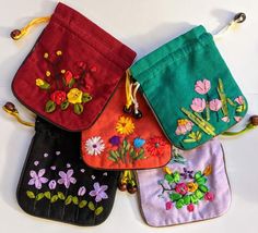 four small purses with embroidered flowers on them