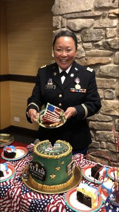 a woman in uniform holding a plate with a cake on it and an american flag table cloth