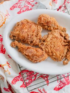 fried chicken on a white plate sitting on a table