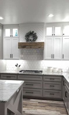 a kitchen with white cabinets and marble counter tops