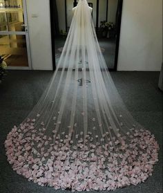 a wedding veil with pink flowers on the floor in front of an entrance to a building