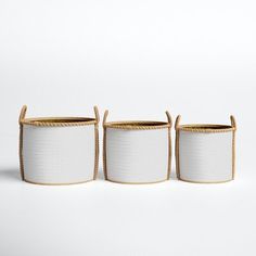 three white baskets with handles on each side and one in the middle, against a white background