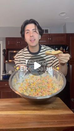 a man holding a plate with food in it on top of a wooden countertop