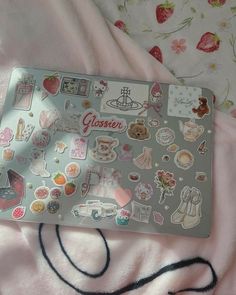 a laptop computer covered in stickers on a bed