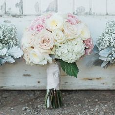 three bouquets of flowers sitting on the ground next to an old wooden door with peeling paint