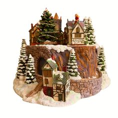 a christmas village with trees and houses on it's sides, including a snow covered hill