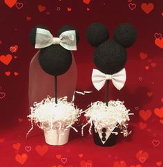 two mickey and minnie mouse heads with bows on top of each other in front of hearts