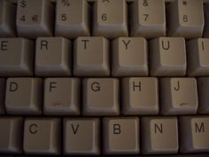 a close up view of a computer keyboard with the letters and numbers written on it