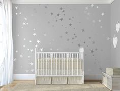 a baby's room with a crib and stars on the wall