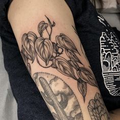 a woman with a tattoo on her arm has a clock and flowers in the background