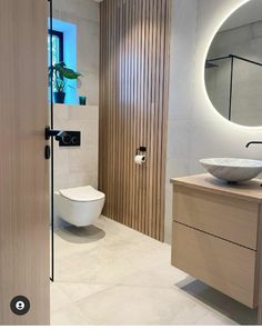 a bathroom with a sink, mirror and toilet in it's center wall area