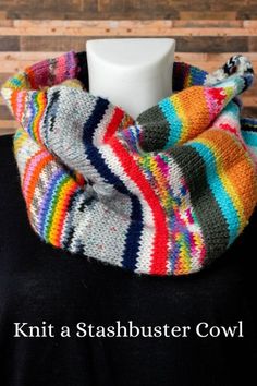 a multicolored knitted cowl sits on a mannequin