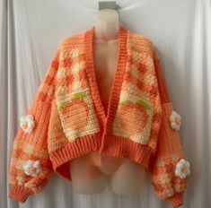 an orange and white sweater with flowers on it