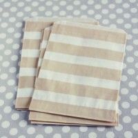 two brown and white napkins sitting on top of a table covered in polka dots