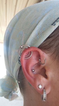 a woman with ear piercings and a towel on her head