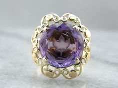 The center of this vintage gemstone is carved with the image of a maple leaf, shining from the center of the purple amethyst! We've set this gemstone into a filigree mounting that balances the unusual centerpiece perfectly! Metal: 14K Yellow Gold Gem: Amethyst 5.42 Carats Gem Measurements: 11.9 mm, Round Ring Size: 7 Unusual Centerpieces, Amethyst Cocktail Ring, Botanical Theme, Vintage Cocktail Ring, Maple Leafs, Round Rings, The Purple, Cocktail Ring, Ring Size 7